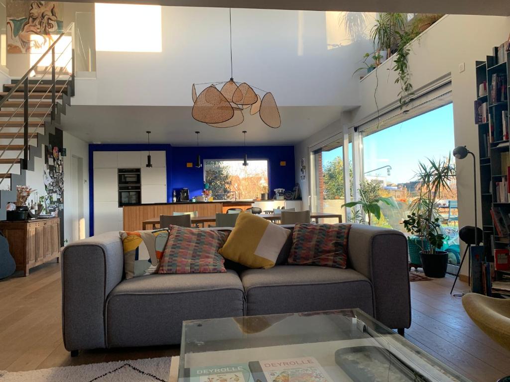 a living room with a couch and a table at Maison spacieuse avec piscine au sel proche grand stade in Sainghin-en-Mélantois