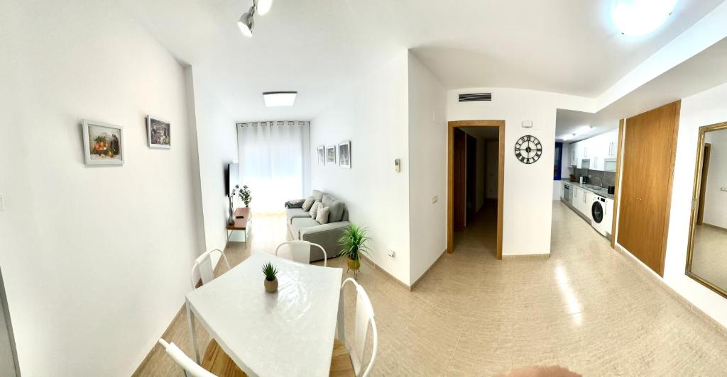 un salon blanc avec un canapé et une table dans l'établissement RelaxMaria, à Sant Carles de la Ràpita