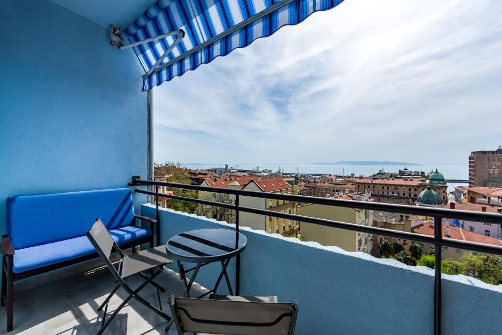 ein Balkon mit Stühlen und Blick auf die Stadt in der Unterkunft Apartments Sunset Centar in Rijeka