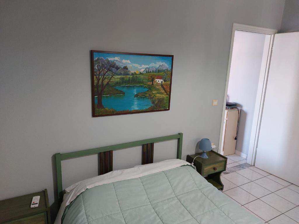 um quarto com uma cama e uma pintura na parede em Marilena Apartments Plataria em Plataria