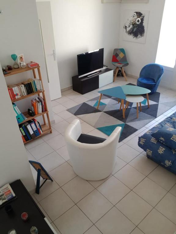 - un salon avec une chaise blanche et une table dans l'établissement Charmant logement au calme en ville, à Nice