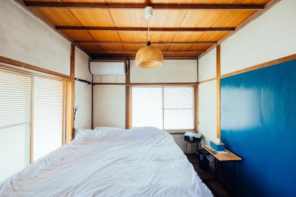 1 dormitorio con 1 cama grande y pared azul en 松本市の一棟貸し切りできる古民家, en Matsumoto