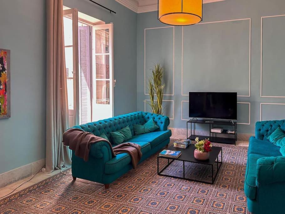 a living room with two blue couches and a tv at Appartement rénové en plein centre historique in Tunis