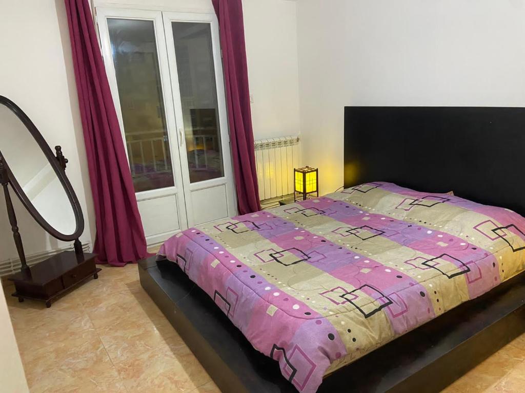 貝賈亞的住宿－Magnifique F3 edimco，一间卧室设有一张床和一个大窗户