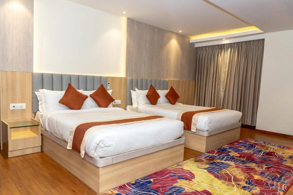 - une chambre d'hôtel avec 2 lits et un tapis dans l'établissement Hotel Badrinath, à Katmandou