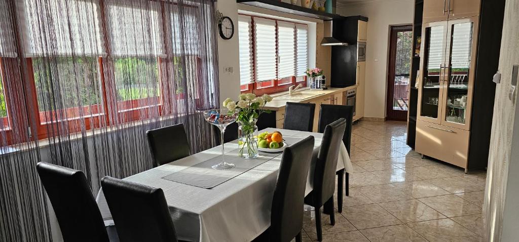 une salle à manger avec une table et des chaises ainsi qu'une cuisine dans l'établissement Nyirjes Vendégház, à Balassagyarmat