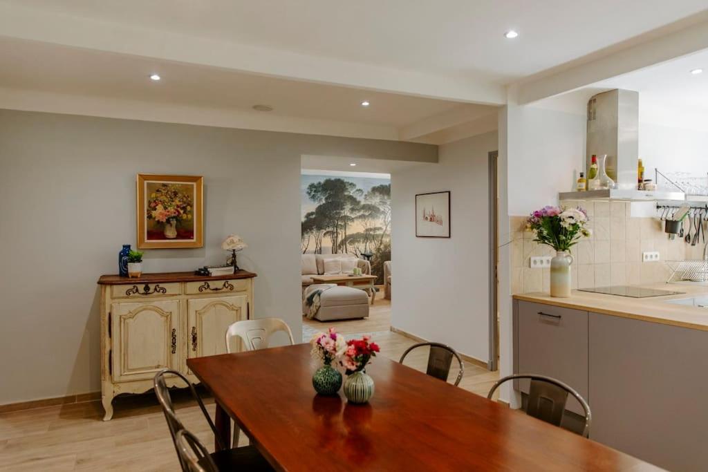 une cuisine et une salle à manger avec une table et des chaises en bois dans l'établissement Maison Gilberte - Avec terrasse au coeur du village, à Châteauneuf-du-Pape