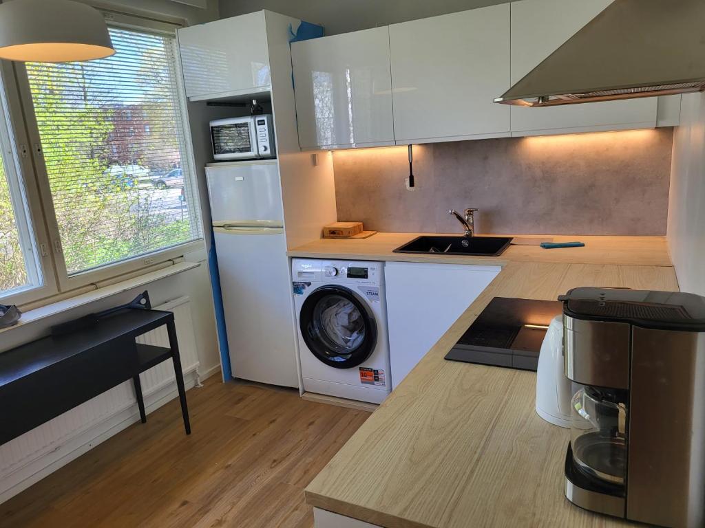 a kitchen with a washing machine and a washer at Convenient Stay Helsinki in Helsinki