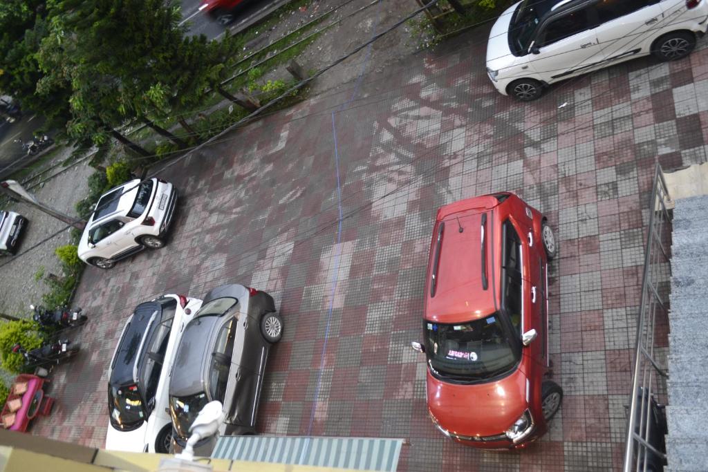 een groep auto's geparkeerd op een parkeerplaats bij O'SKY INN in Siliguri