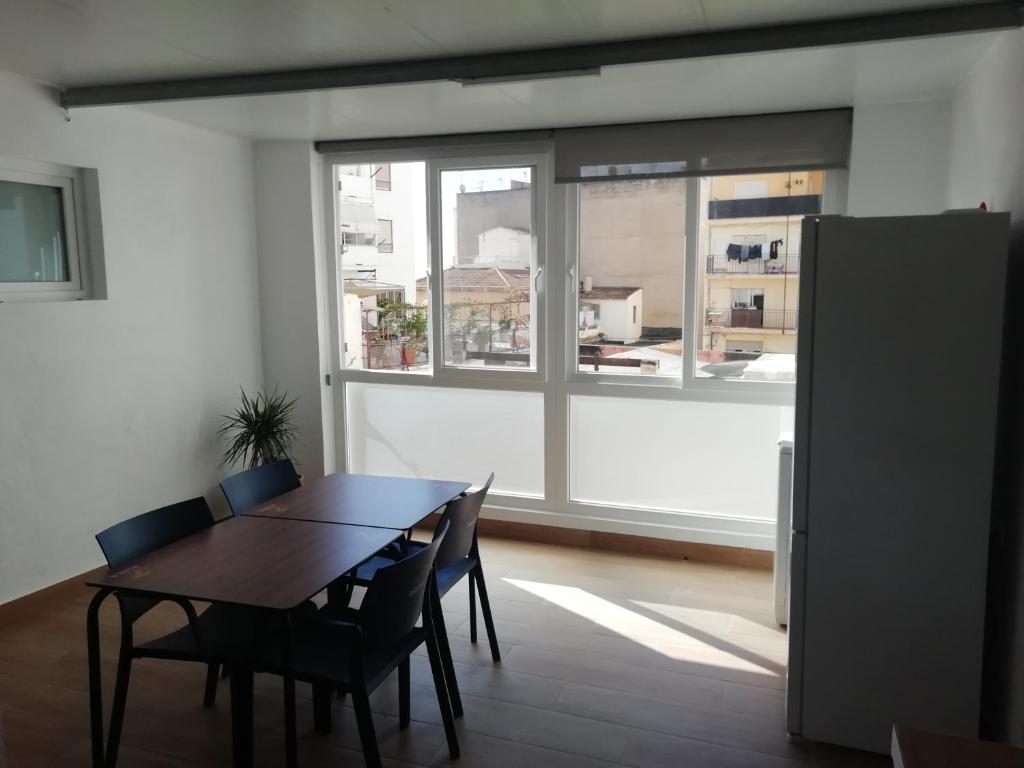 ein Esszimmer mit einem Tisch, Stühlen und einem Fenster in der Unterkunft casa de tres habitaciones con parking bajo la casa in Villajoyosa