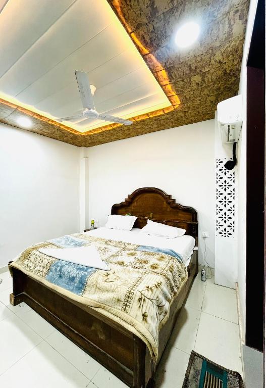a bedroom with a bed with a coffered ceiling at Shri Hari Cottage in Mathura
