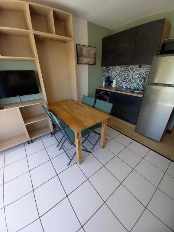 une cuisine avec une table en bois et un réfrigérateur dans l'établissement Studio 4 personnes vue MER et PORT, au Grau-du-Roi