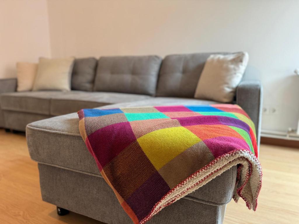 una coperta colorata seduta sopra un divano di Fantástico apartamento cerca de Santander a El Astillero