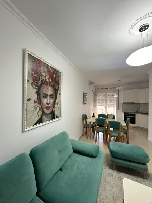 un salon avec un canapé vert et une salle à manger dans l'établissement Lungo mare holiday apartment for family, à Vlorë