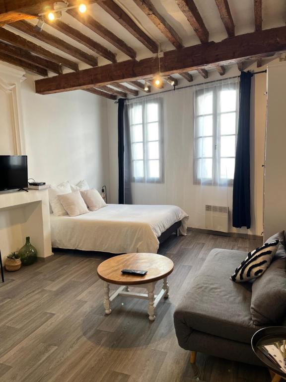 1 dormitorio con 2 camas, sofá y mesa en Studio Charmant au Cœur de Carpentras, en Carpentras