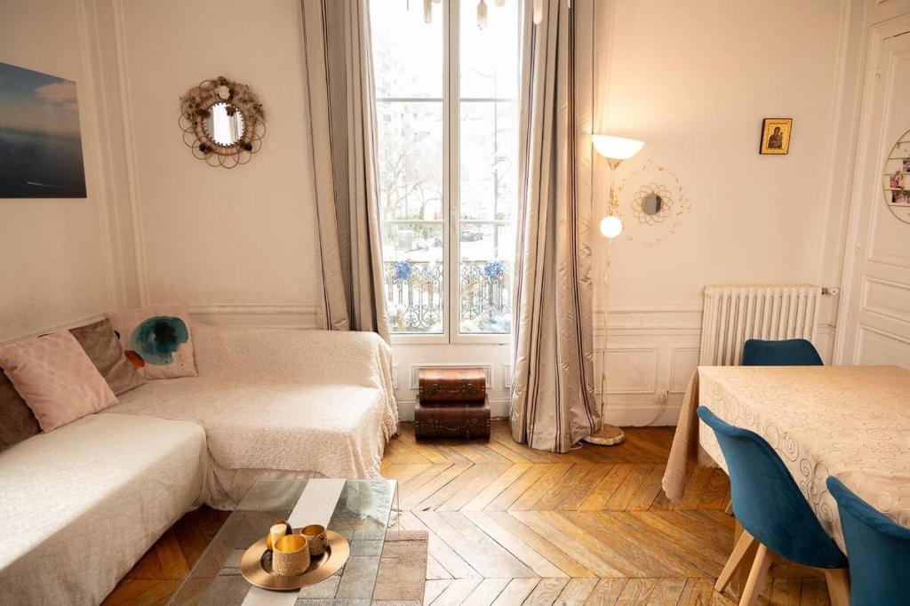 un salon avec un canapé et une table dans l'établissement Appartement location T3 Paris 11, à Paris
