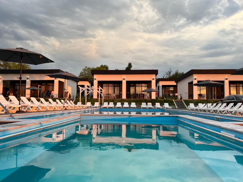 a swimming pool with chairs and an umbrella at Modern House in Solotvyno