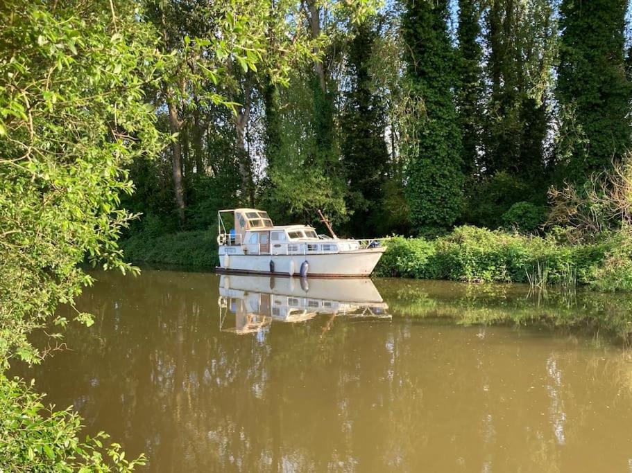 a boat sitting on the water in a river at Dutch Cruiser Ship on a Tranquil Secluded River in Tonbridge