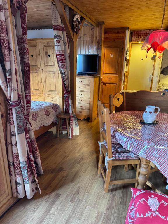 - une chambre avec une table, un lit et une télévision dans l'établissement Appartement cosy a Montchavin, à La Plagne Tarentaise