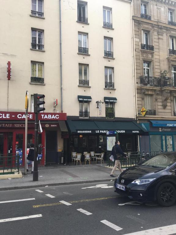 une voiture garée dans une rue devant un immeuble dans l'établissement le paris saint ouen, à Paris