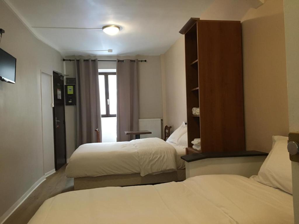 ein Hotelzimmer mit 2 Betten und einem Spiegel in der Unterkunft le paris saint ouen in Paris