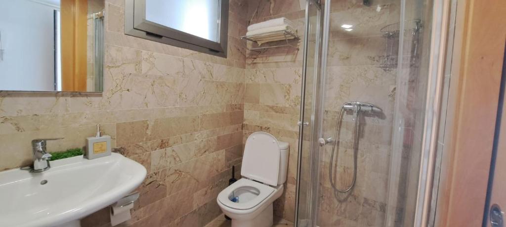 a bathroom with a shower and a toilet and a sink at Holiday Marina D'or in Oropesa del Mar
