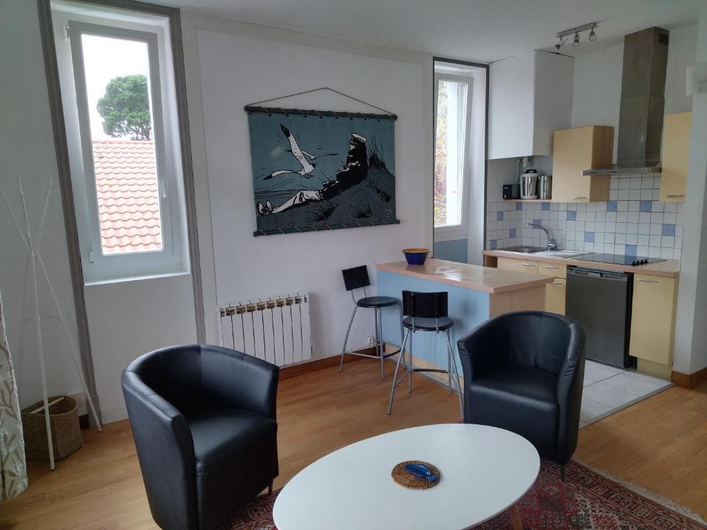 une cuisine avec deux chaises, une table et une table dans l'établissement Studio Baulois, à La Baule