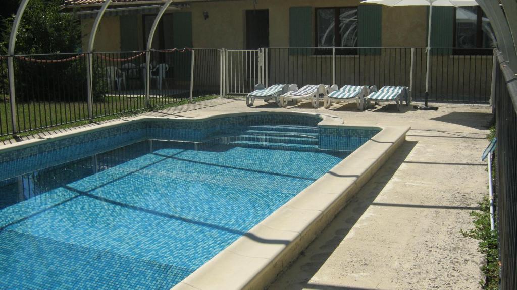 - une piscine avec 2 chaises longues dans l'établissement Maison a la campagne, à Serres-et-Monguyard