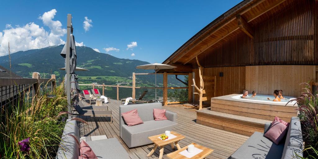 a patio with a hot tub and a woman in a bath tub at Widmannhof - Urlaub auf dem Biobauernhof in Bressanone