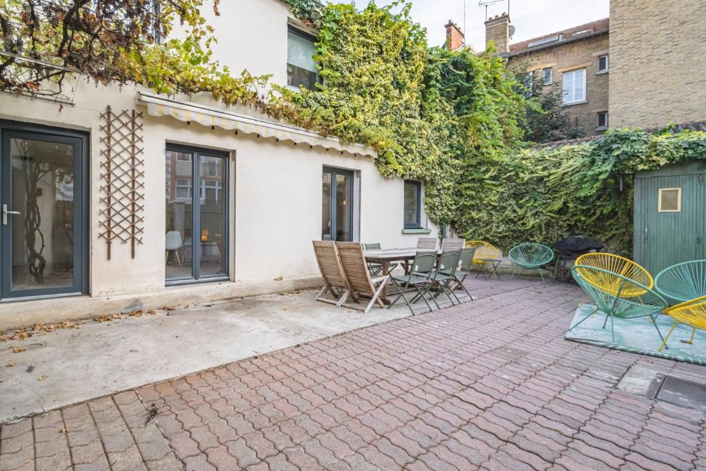 un patio avec une table et des chaises dessus dans l'établissement Charmante maison proche centre-ville Reims, à Reims