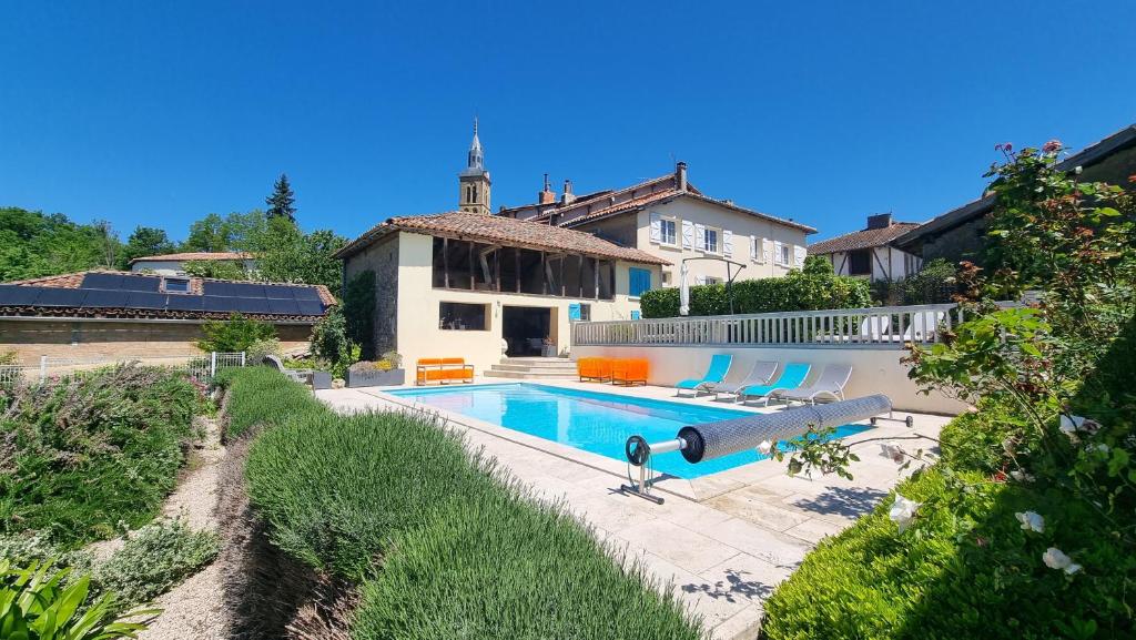 een huis met een zwembad in een tuin bij Maison avec grange & piscine vue sur les Pyrénées in Puymaurin