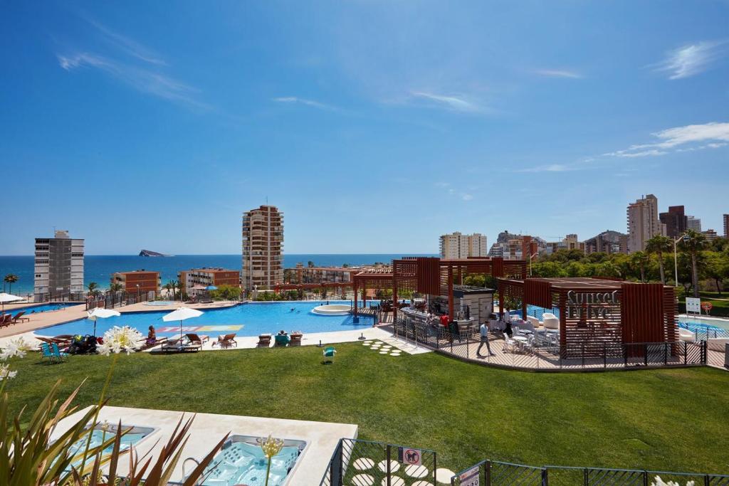 a large swimming pool with a city in the background at Amazing Apartment in Benidorm - Sunset in Benidorm