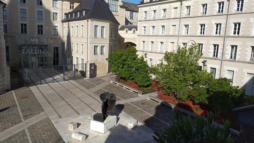 une statue dans une cour devant un bâtiment dans l'établissement Appart 2 pièces et jardin hyper centre ville, à Angers