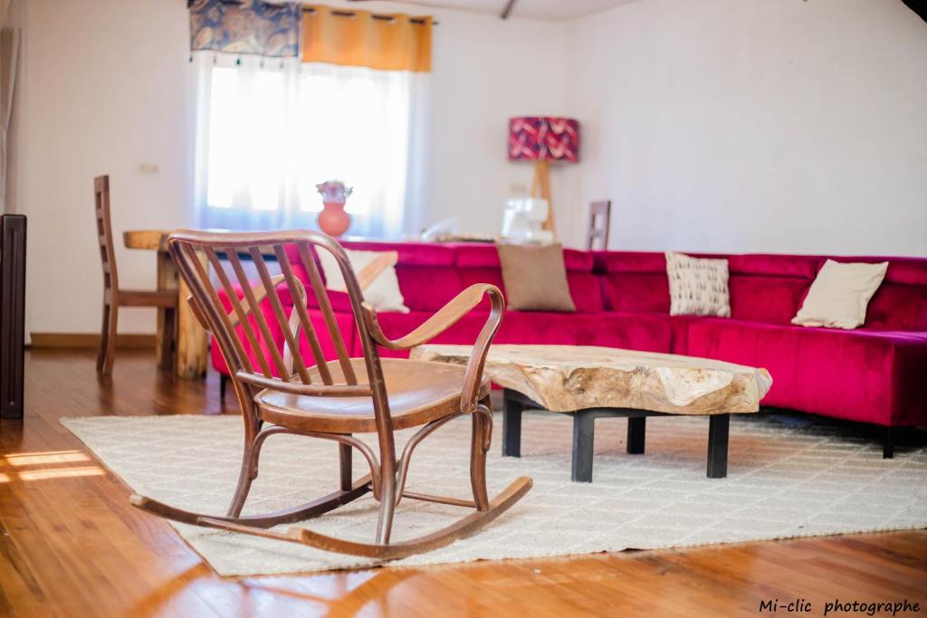 uma sala de estar com um sofá vermelho e 2 cadeiras de baloiço em MANGA BLUE'S GUEST HOUSE em Fianarantsoa