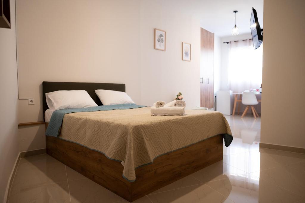 a bedroom with a bed with a stuffed animal on it at Anesis Airport Rooms 408 in Koropíon
