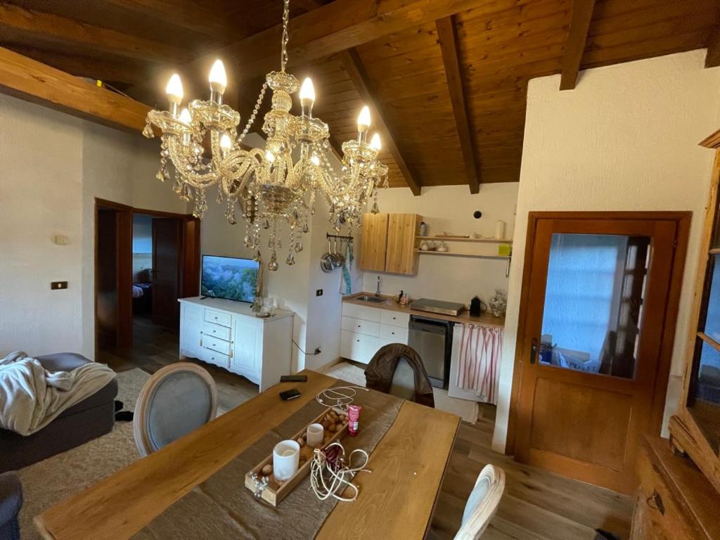 ein Wohnzimmer mit einem Esstisch und einem Kronleuchter in der Unterkunft I Pascoli in Roana