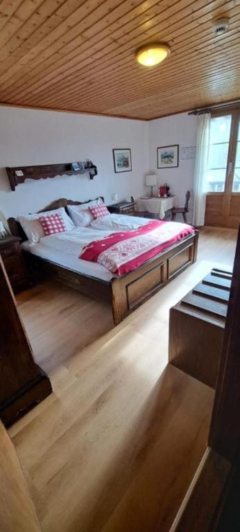 a bedroom with a large bed with a wooden ceiling at Hotel Fassbind Beausite in Beatenberg