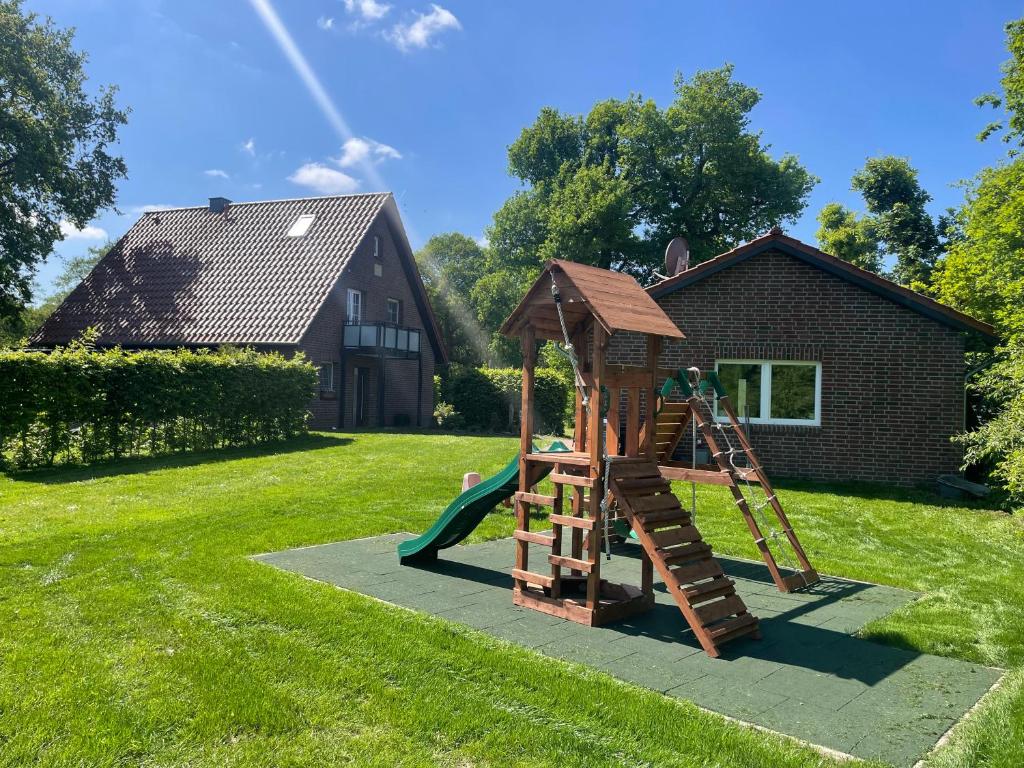 een speeltuin in een tuin met een glijbaan bij Ferienhaus Jahn in Barßel