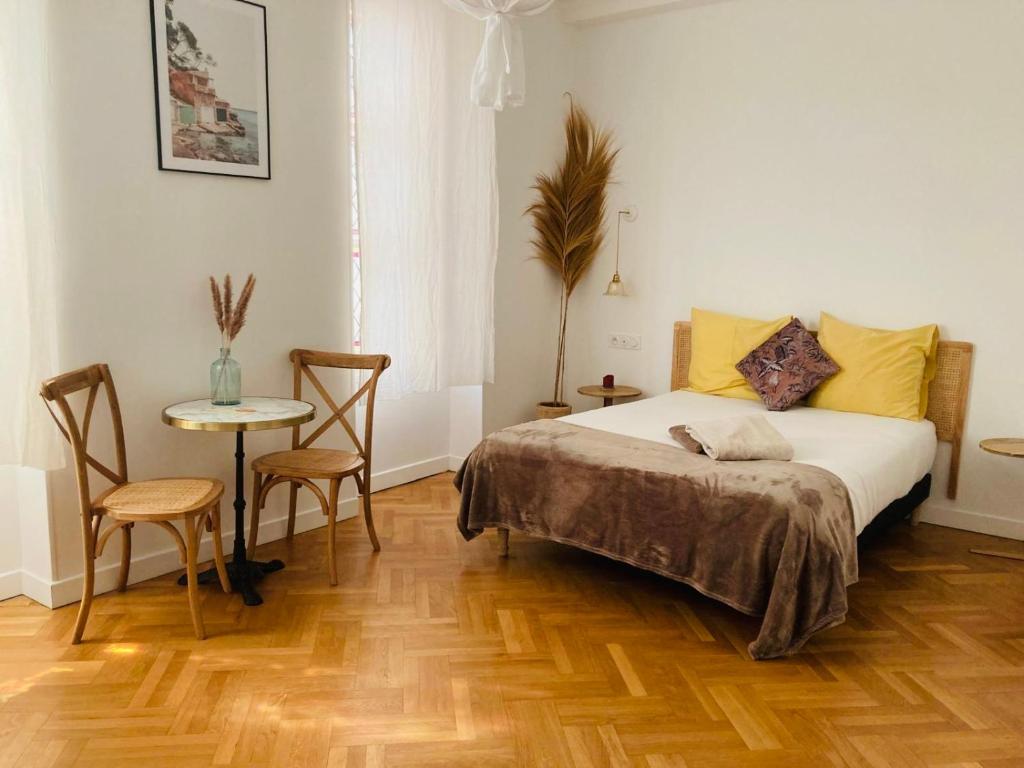 une chambre avec un lit et une table avec des chaises dans l'établissement - - Maison ŪMA - - Wifi, Netflix, Mer et Centre, à Marseille