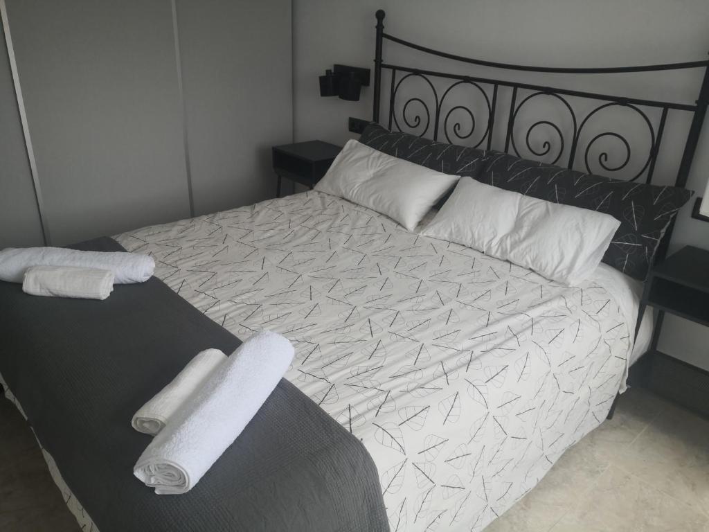 a bedroom with a bed with two towels on it at O RECUNCHO DE MORA in Ribeira