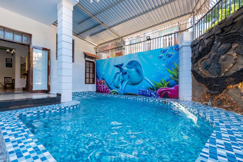 a swimming pool in a building with a mural at Villa Hồ Bơi 47 - Gần Biển Bãi Sau - Phòng Khách Có Máy Lạnh in Vung Tau