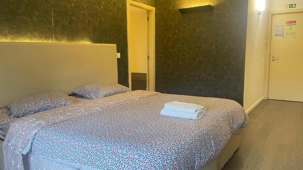 1 dormitorio con 1 cama con 2 toallas en Campanhã Studios, en Oporto