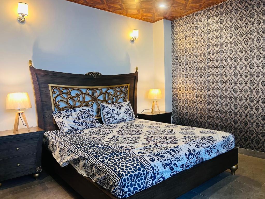 1 dormitorio con 1 cama con sábanas azules y blancas en Blue sky Apartment, en Nathia Gali