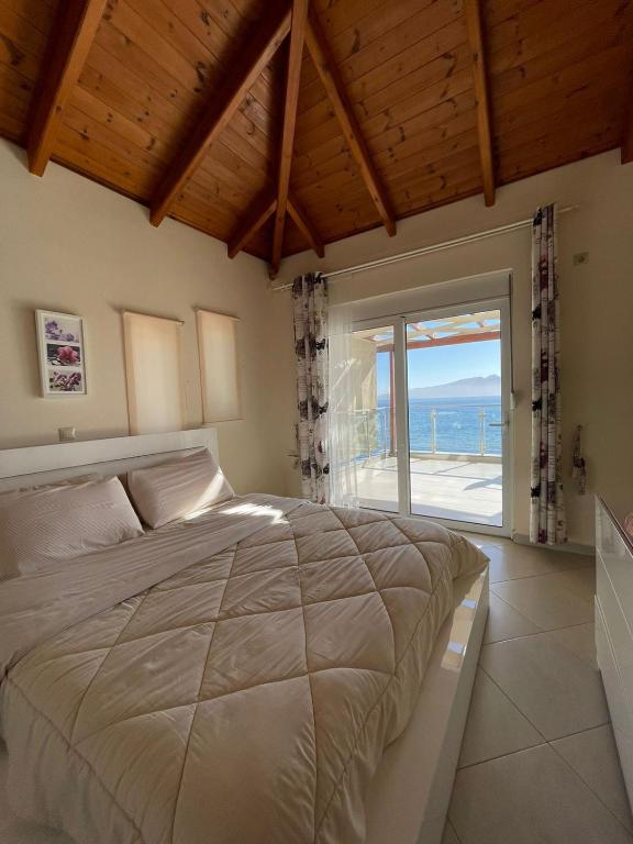 una camera da letto con un letto con vista sull'oceano di Anna Apartments a Sarandë