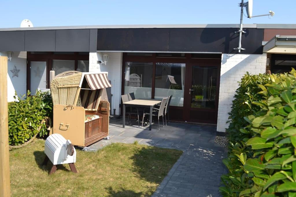 a house with a table and chairs in the yard at Ferienwohnung Skagen in Westerdeichstrich