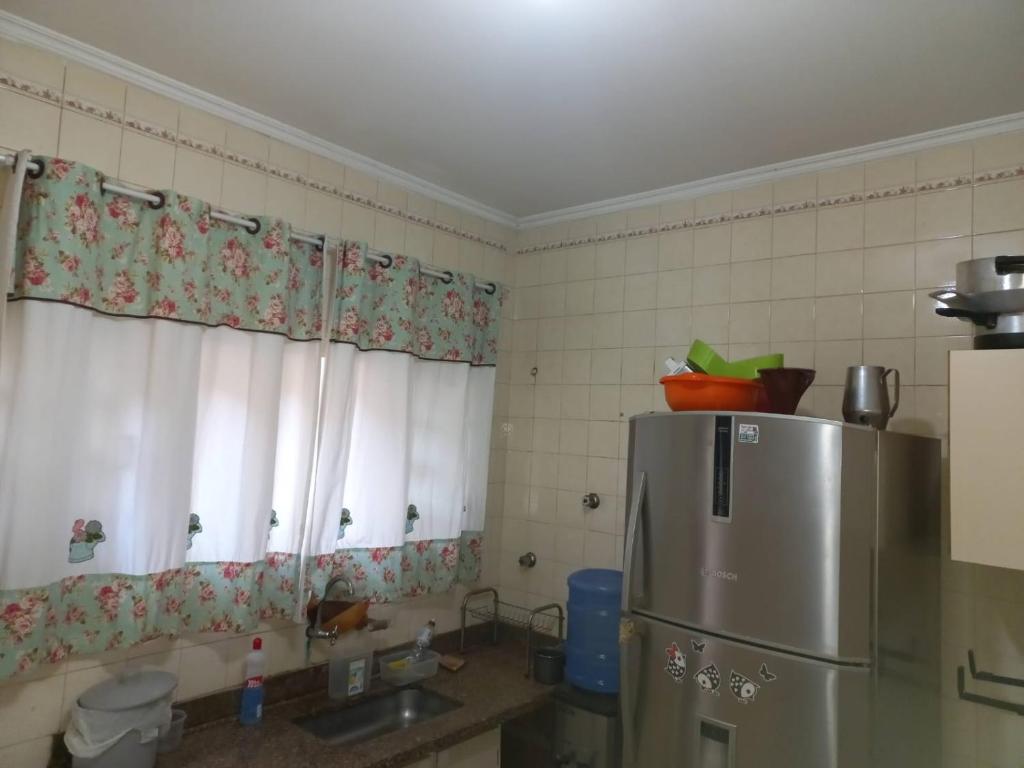uma cozinha com um frigorífico de aço inoxidável e janelas em SOBRADO Zona Sul Ribeirao Preto em Ribeirão Preto