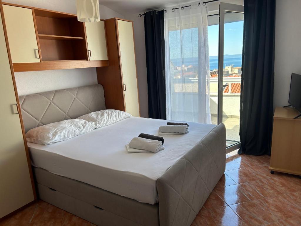 ein Schlafzimmer mit einem Bett mit zwei Handtüchern darauf in der Unterkunft Apartmani Jukanovic in Baška Voda