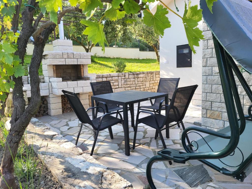 - une table et des chaises noires sur la terrasse dans l'établissement Oasis apartment, à Koper