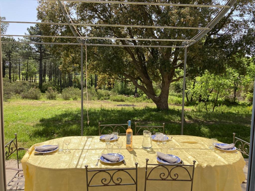 a table with a yellow table cloth on it at Villa provençale dans le Golfe de Saint Tropez in Grimaud