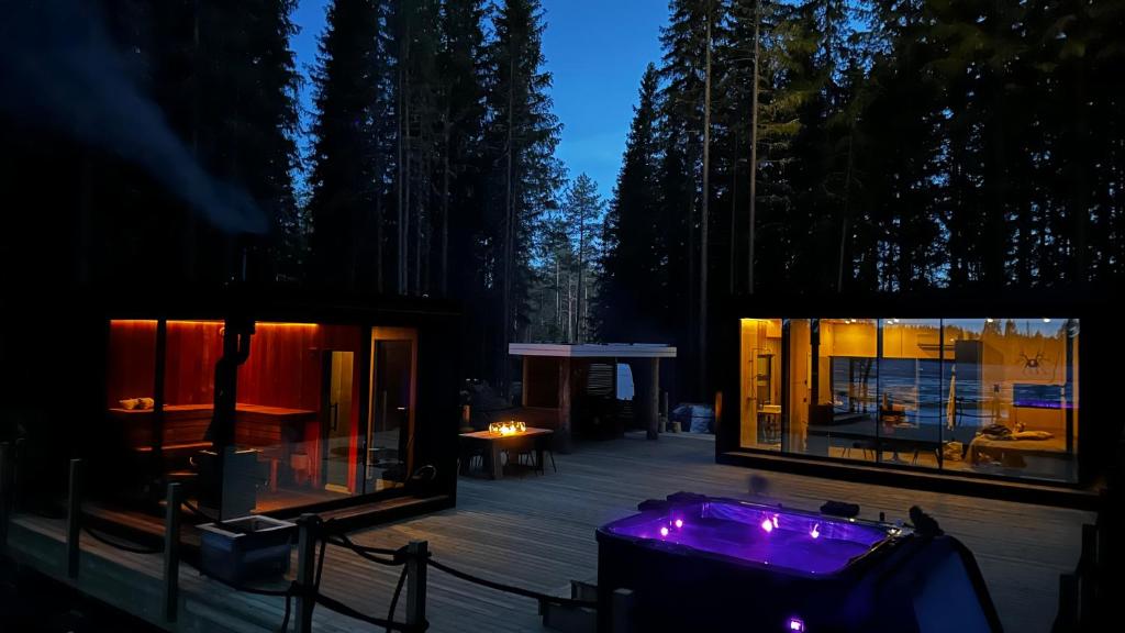 una casa con vasca idromassaggio su una terrazza di notte di Minivilla Lapland 